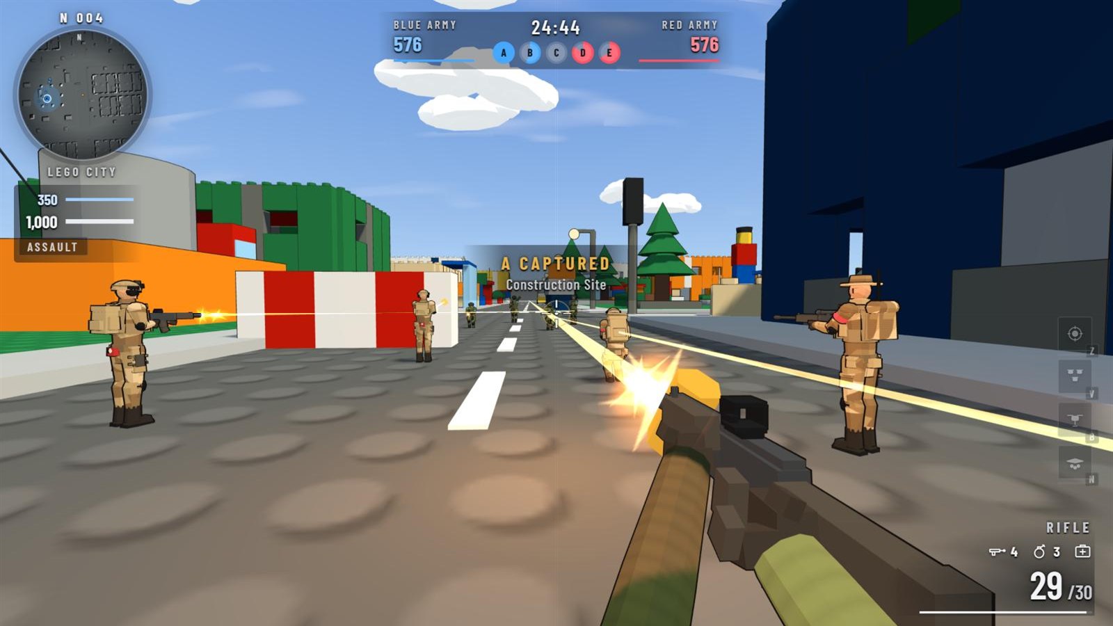 First-person view firing a rifle down a Lego City street at desert-camo soldiers, with the minimap, score bar, health and ammo on screen.